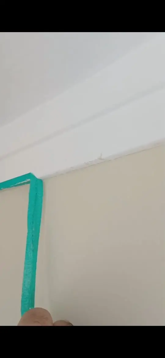 Fita de proteção no encontro entre parede e teto antes da pintura