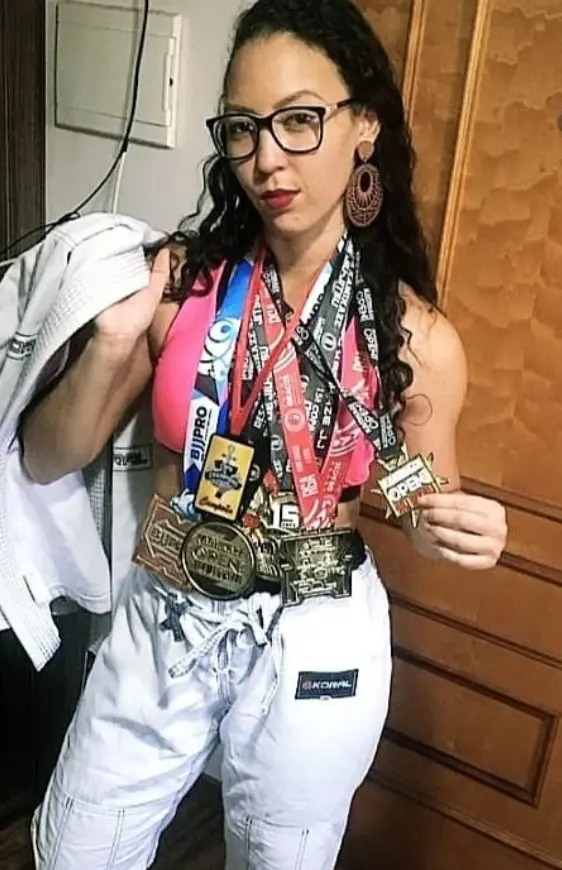 Tamires França sorrindo com colegas de treino em academia de jiu-jitsu